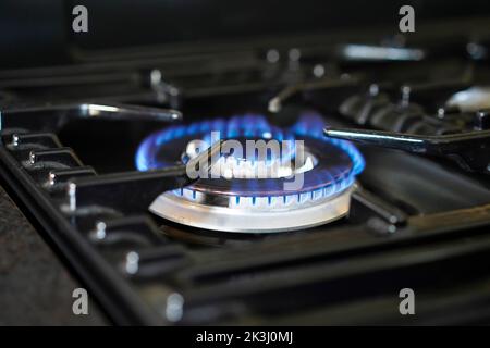 Crisi dell'energia del gas. Fiamma blu su un anello di gas del fornello. Foto Stock