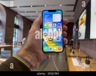 Parigi, Francia - 16 settembre 2022: POV mano maschio tenere nuovo color viola Apple computer iPhone 14 durante il giorno di lancio con la nuova fotocamera doppia potente auto rilevamento urti e satellite SOS Foto Stock