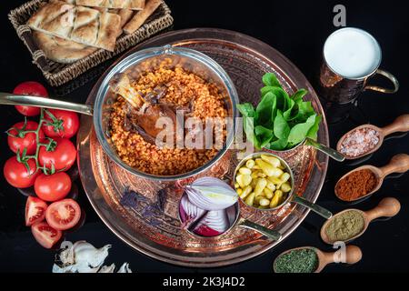Tradizionale turco cibo gambo di agnello e riso. Gambo di agnello cotto lento. Gambo di agnello servito su un vassoio di rame e in una ciotola di rame. Foto Stock