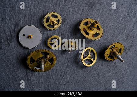 Vecchi ingranaggi di metall da orologi meccanici ardesia fondo in pietra Foto Stock