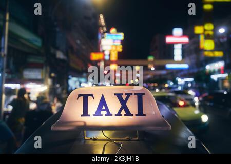 Cartello taxi illuminato sul tetto di tuk tuk. Traffico notturno a Chinatown a Bangkok, Thailandia, Foto Stock