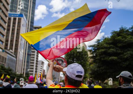 Un dimostratore sventola una bandiera colombiana durante la prima protesta contro il presidente di sinistra Gustavo Petro e la sua iniziativa su una re fiscale Foto Stock