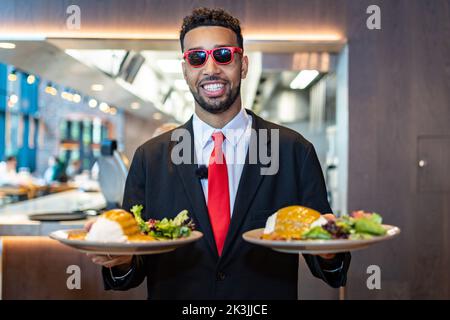 SOLO PER USO EDITORIALE YouTuber e il comico Niko Omilana visitano il wagamama a St Peters Square, Manchester, mentre la catena di ristoranti offre curry katsu gratuiti ai primi 50 studenti universitari in ciascuno dei suoi ristoranti per celebrare il National Katsu Curry Day. Data immagine Martedì, Settembre 27, 2022. Foto Stock