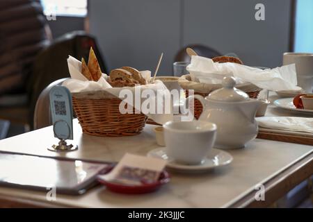 Un teiera e un cestino con pane sono visti in un caffè in un ex quartiere ebraico a Varsavia, Polonia, il 26 settembre 2022. (Foto di Jaap Arriens / Sipa USA) Foto Stock