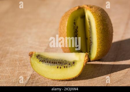 Vista ravvicinata della frutta kiwi tagliata all'aperto su un asse di legno nel sud della Francia Foto Stock