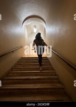 Donna sale una rampa di scale alla Morgan Library and Museum di New York City. Foto Stock