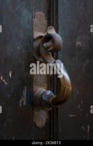 Vista dall'alto della maniglia in ottone vintage con bella patina isolata su un'antica porta in legno marrone scuro, Montpellier, Francia Foto Stock