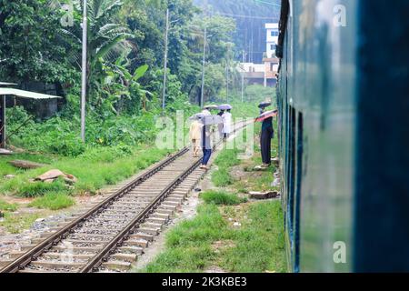 La gente aspetta sotto la pioggia per il treno. E' una stazione ferroviaria piovosa. Università di Chittagong, Bangladesh stazione ferroviaria. Foto Stock