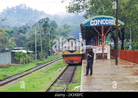 La gente aspetta sotto la pioggia per il treno. E' una stazione ferroviaria piovosa. Università di Chittagong, Bangladesh stazione ferroviaria. Foto Stock