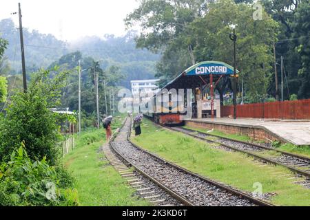 La gente aspetta sotto la pioggia per il treno. E' una stazione ferroviaria piovosa. Università di Chittagong, Bangladesh stazione ferroviaria. Foto Stock