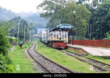 La gente aspetta sotto la pioggia per il treno. E' una stazione ferroviaria piovosa. Università di Chittagong, Bangladesh stazione ferroviaria. Foto Stock