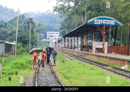 La gente aspetta sotto la pioggia per il treno. E' una stazione ferroviaria piovosa. Università di Chittagong, Bangladesh stazione ferroviaria. Foto Stock