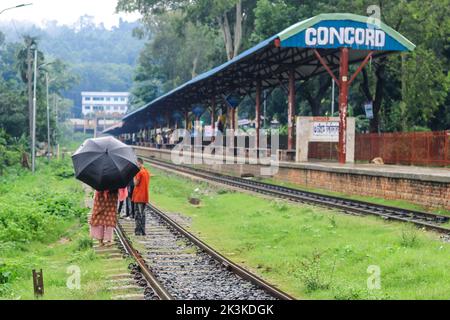 La gente aspetta sotto la pioggia per il treno. E' una stazione ferroviaria piovosa. Università di Chittagong, Bangladesh stazione ferroviaria. Foto Stock