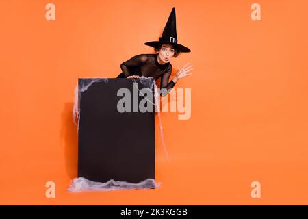 Foto a tutta lunghezza del misterioso stregone mano terrificante boo spazio vuoto poster isolato su sfondo di colore arancione Foto Stock