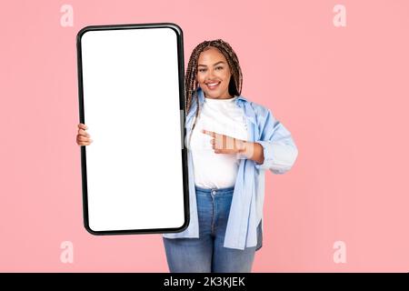 Felice African American Lady Holding cellulare grande su sfondo rosa Foto Stock