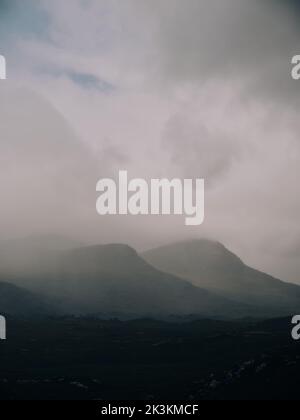 Un nuvoloso scuro e arido drammatico paesaggio di montagna a bassa nuvola nelle Highlands occidentali della Scozia UK - copia spazio Foto Stock