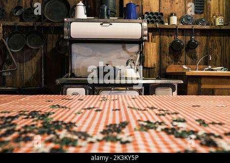 Pentola da cucina e bollitore seduti in cima a un antico fornello in una cucina in stile antico. Foto Stock