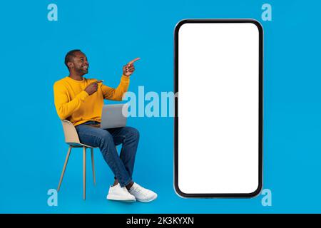Uomo afro-americano positivo con computer in grembo Foto Stock