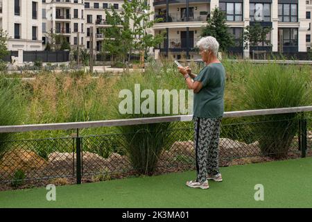 Una persona anziana scrive o legge un SMS sul suo cellulare Foto Stock