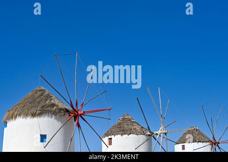 Mykonos, Grecia - 2022 maggio: Tre dei famosi mulini a vento tradizionali in fila sull'isola greca di Mykonos Foto Stock