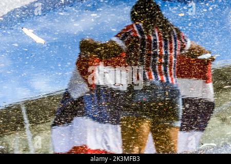 Salvador, Bahia, Brasile - 01 aprile 2018: Tifosi della squadra di calcio di Esporte Clube Bahia, visto attraverso il riflesso dell'acqua nel vicinit Foto Stock