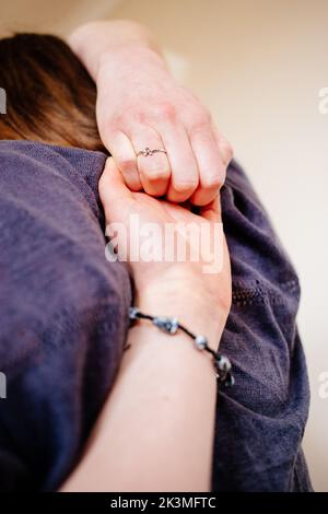 Una donna che tocca le mani dietro la schiena durante un esercizio di yoga Foto Stock