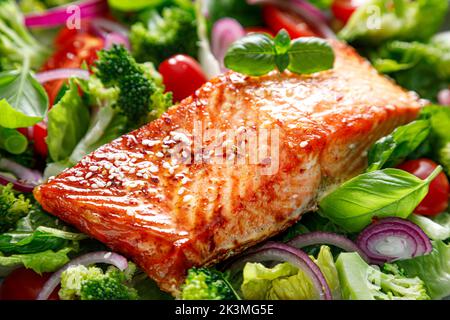 Filetto di salmone alla griglia e insalata di pomodoro fresco con cipolla rossa e broccoli. Cibo sano, dieta. Pranzo chetogenico Foto Stock