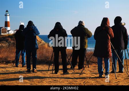 Un gruppo di amici in un club bird watchers posizionare i loro telescopi vicino al faro di Montauk Point per contare durante la migrazione invernale Foto Stock