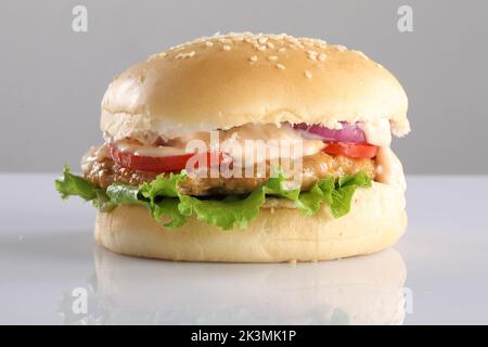 CROCCANTE POLLO CHEESY PATTY BURGER SU SFONDO BIANCO Foto Stock