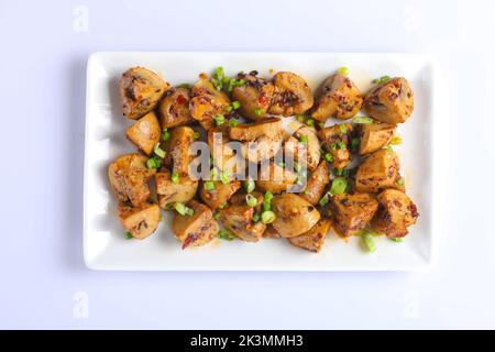 funghi di castagno all'aglio al ajillo o champignons arrosto con prezzemolo tritato servito su una padella su fondo bianco Foto Stock