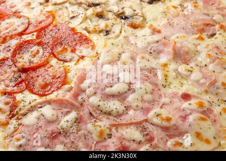 Pizza sfondo - macro shot di pizza italiana quattro stagioni. Può essere utilizzato come sfondo astratto dell'alimento. Foto Stock