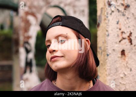 Ritratto di ragazza giovane punk con sopracciglia trafitto in cappuccio all'indietro Foto Stock