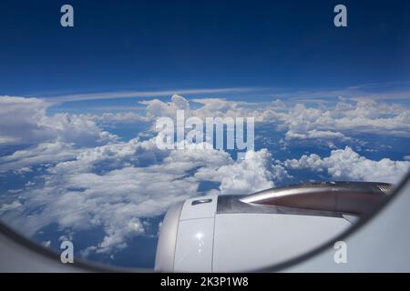 Vista di belle nuvole nel cielo da una finestra di un aereo Foto Stock