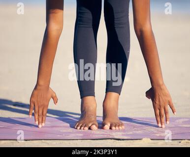 Stendetelo fuori. Una donna irriconoscibile che pratica yoga sulla spiaggia. Foto Stock