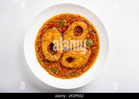 Ruhu rui o Katla Fish curry, tradizionale bangali curry di pesce, disposti in una ciotola di ceramica bianca guarnita con fresco rosso freddo e foglie di curry su un Foto Stock