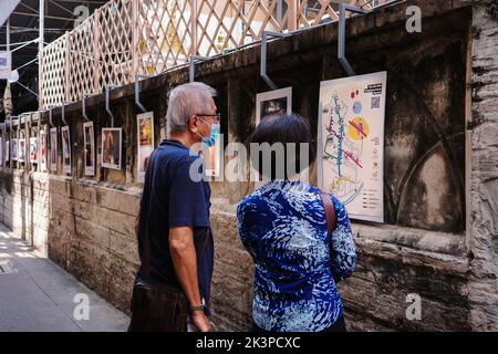 Bangkok, Thailandia - 13 febbraio 2022: Coppia anziana stanno guardando la mappa stradale su muro decorato da foto che mostrano la cultura e la vita in Talad No Foto Stock