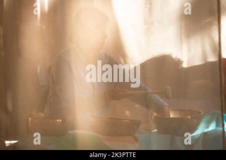 Campane tibetane terapia, Singing Bowl nelle mani di un terapista Foto Stock