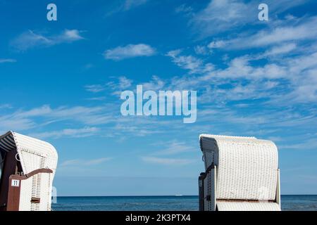 Una tradizionale spiaggia bianca in vimini cesti sulla spiaggia con il Mar Baltico, a Poel, Germania Foto Stock