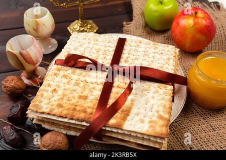Festa ebraica della Pasqua design banner con vino, matzo su sfondo di legno. Foto Stock