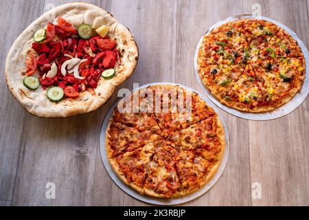 Deliziose pizze fatte a mano e tikka di pollo sul naan dall'alto Foto Stock