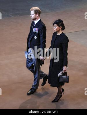 Il principe Harry e Meghan Markle tengono le mani, il duca e la duchessa di Sussex partono dal servizio per l'arrivo della bara della regina Elisabetta II al Palazzo di Westmin Foto Stock