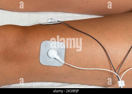 Elettrodo autoadesivo TENS (stimolazione elettrica transcutanea dei nervi) e EMS (stimolazione elettronica dei muscoli) Unit Therapy Machine Foto Stock