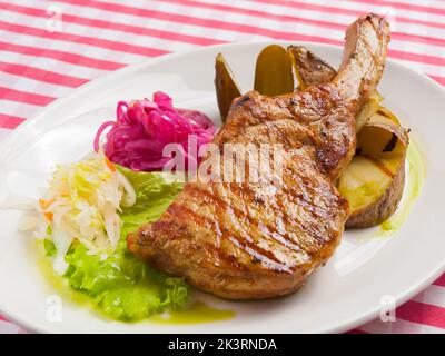 gustoso lombo di maiale su carboni con patate e cavolo Foto Stock