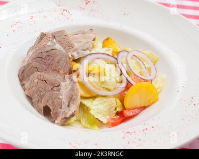 insalata gustosa con agnello e verdure: patate cipolle pomodori. Cucina tradizionale del Montenegro Foto Stock