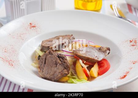insalata gustosa con agnello e verdure: patate cipolle pomodori. Cucina tradizionale del Montenegro Foto Stock