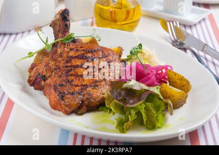 gustoso lombo di maiale su carboni con patate e cavolo Foto Stock