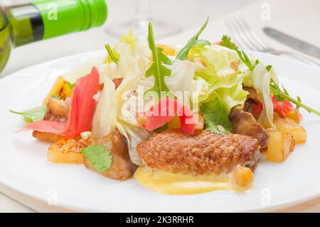 insalata gustosa con ali di pollo, patate all'ananas, rucola allo zenzero Foto Stock