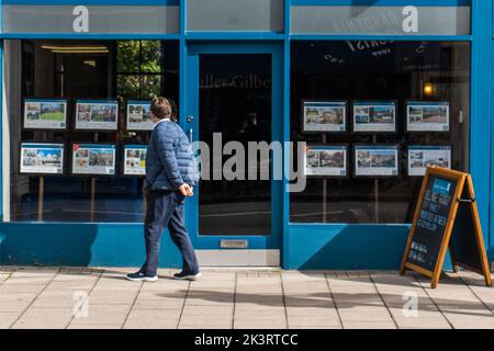 Londra Regno Unito. 28 settembre 2022 . Un membro del pubblico che guarda le proprietà pubblicizzate da un agente immobiliare in Wimbledon alta strada. I prestatori di mutui ipotecari britannici hanno ritirato gli accordi per gli acquisti di case in risposta ai tassi di interesse alle impennate annunciati dalla banca d'Inghilterra a seguito del drammatico crollo della sterlina nei confronti del dollaro americano dopo che il cancelliere Kwasi Kwarteng ha svelato un importante pacchetto di tagli fiscali, finanziato da prestiti extra, accanto a un enorme salvataggio per congelare le bollette energetiche . Credit: amer Ghazzal/Alamy Live News. Foto Stock