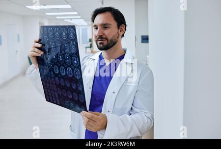 Diagnostica di malattie cerebrali, mal di testa, tumori e cancro cerebrale con MRI o CT scan. Neurologo medico esperto che esamina la risonanza magnetica del paziente Foto Stock