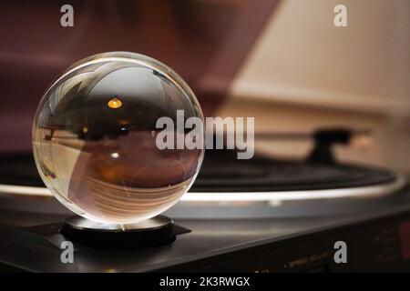 Una sfera di vetro con riflessione inversa su un disco. Foto Stock